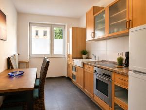 a kitchen with wooden cabinets and a table and a window at Apartments am Heimbach EG rechts in Kassel
