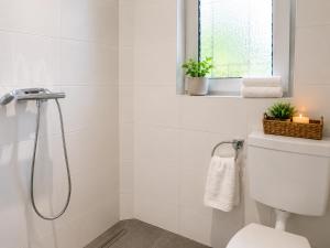 a white bathroom with a shower and a toilet at Apartments am Heimbach EG rechts in Kassel