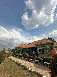a house with benches in front of a yard at Ashland Gardens in Vumba