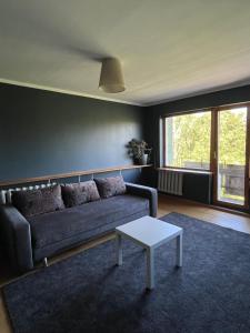 a living room with a couch and a table at Aluksne city nest in Alūksne