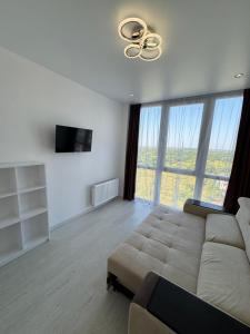 a living room with a couch and a large window at Panorama Apartment in Lviv