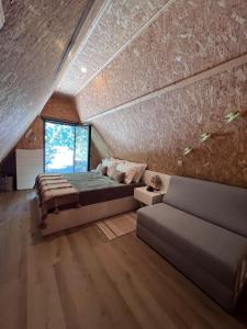 ein Schlafzimmer mit einem großen Bett und einer Couch in der Unterkunft Zebral in Vieira do Minho