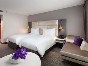 a hotel room with two beds and a couch at Sofitel Warsaw Victoria in Warsaw +234 photos