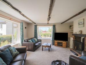 a living room with couches and a flat screen tv at Woodstock in Chard