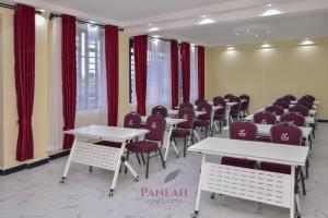a room with tables and chairs and red curtains at Paneah hotel and suites in Nairobi