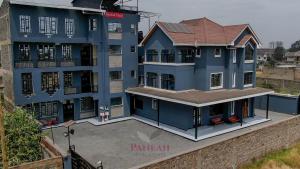 a large blue building with chairs in front of it at Paneah hotel and suites in Nairobi