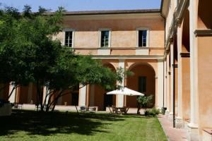 a building with an umbrella in the yard of a house at Student's Hostel Della Ghiara in Reggio Emilia