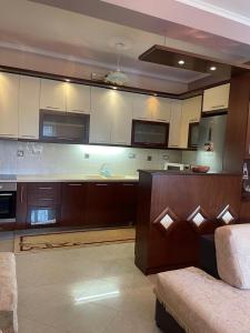 a large kitchen with white cabinets and a couch at Stone House Leskovik in Leskovik