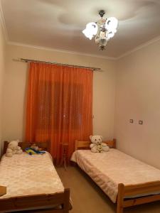 two beds in a room with two teddy bears on them at Stone House Leskovik in Leskovik