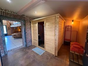 a room with a brick wall and a room with a door at Odyssée - Chambre d'hôtes avec sauna privatifs, spa et filet suspendu in Zeggers-Cappel
