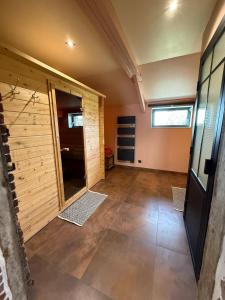 a large room with a wooden wall and a hallway at Odyssée - Chambre d'hôtes avec sauna privatifs, spa et filet suspendu in Zeggers-Cappel +28 photos