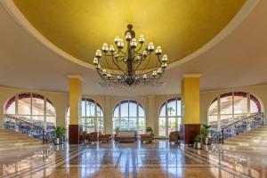 a large lobby with a chandelier on the ceiling at Ohtels La Hacienda in La Pineda +29 photos