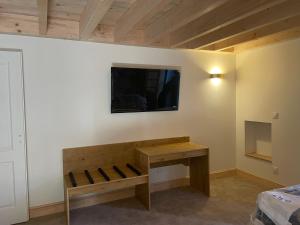 a room with a wooden bench and a tv on the wall at La Promesse by Hillis in Marennes