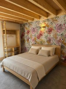 a bedroom with a large bed with a floral wall at La Promesse by Hillis in Marennes