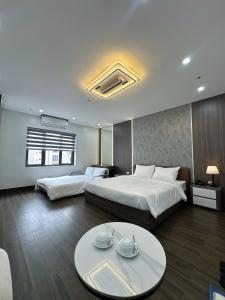 a hotel room with two beds and a table at Elegant Hotel in Hanoi +16 photos