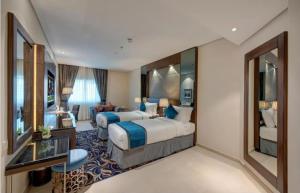 a hotel room with two beds and a living room at Hotel The De - Pacific Suites Near Delhi IGI Airport in New Delhi