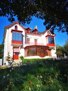 a large white house with red windows at Mercure Granville Le Grand Large in Granville