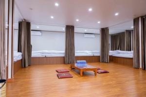 a room with two beds and a table in it at Thái house Mộc Châu in Bản Chiềng Di