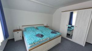 a bedroom with a blue bed and a mirror at Goode Wind in Norden