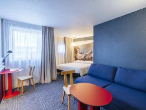 a hotel room with a couch and a bed at ibis Styles Le Mans Gare Sud in Le Mans