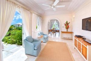a living room with two chairs and a television at Fairway Views with Private Pool - High Spirits in Saint James