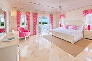 a bedroom with a white bed and pink curtains at Fairway Views with Private Pool - High Spirits in Saint James +13 photos