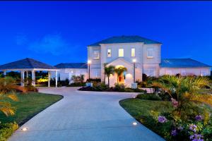 a large white house with a driveway at night at Fairway Views with Private Pool - High Spirits in Saint James