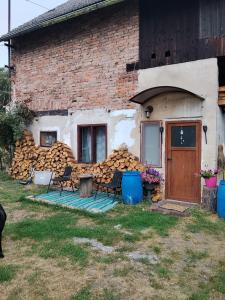 a building with a pile of fire wood at Vejminek u hospodářství Obora u Doks in Doksy