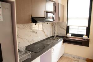 a kitchen with a marble counter top and a sink at Residence Hôtel le Danoré Bastos in Yaoundé +67 photos