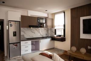 a kitchen with a refrigerator and a counter top at Residence Hôtel le Danoré Bastos in Yaoundé