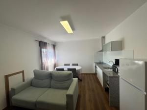 a living room with a couch and a kitchen at Alojamentos do Conde in Ponte de Lima