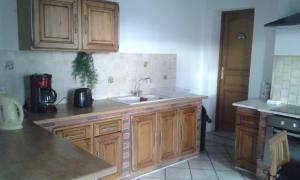 a kitchen with wooden cabinets and a sink at Entre Terre et Mer in Oye-Plage