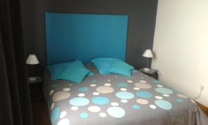a bedroom with a bed with a blue headboard and pillows at Entre Terre et Mer in Oye-Plage