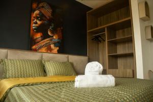 a bedroom with a bed with a painting on the wall at Residence Hôtel le Danoré Bastos in Yaoundé