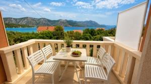 a table and chairs on a balcony with a view at Apartments Oxygen in Račišće