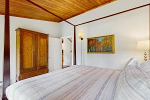 a bedroom with a large bed and a wooden ceiling at Griffin Chalet 5 in Stowe