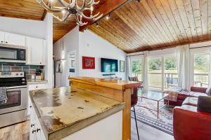 a kitchen with a counter top and a living room at Griffin Chalet 5 in Stowe