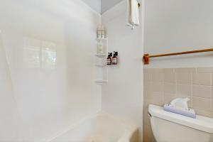a white bathroom with a shower and a toilet at Griffin Chalet 5 in Stowe +26 photos
