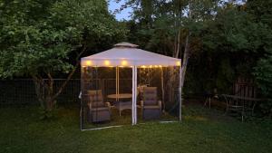 a gazebo with chairs and a table and lights at Mirror House Roosi 21 in Pärnu