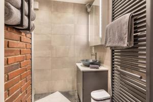 a bathroom with a sink and a brick wall at Ferienwohnung Stillblick in Gersthofen +19 photos