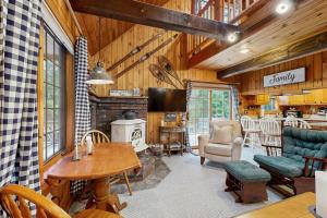 a living room with a fireplace and a table and chairs at Four Seasons at the Lake in Bridgton