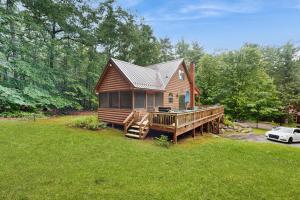 a wooden house with a porch and a deck at Four Seasons at the Lake in Bridgton