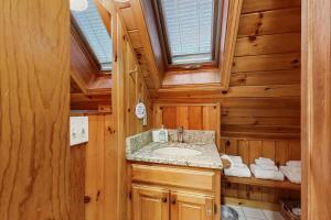 a bathroom with a sink in a wooden house at Four Seasons at the Lake in Bridgton +28 photos