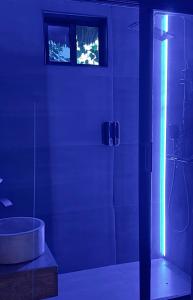 a bathroom with a tub and a shower with lights at King Simba Apartment Hotel & Restaurant in Bwejuu