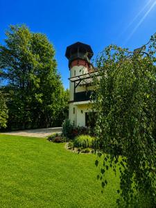 a lighthouse sitting on top of a lush green field at Apartments Zámoček Staré časy in Poprad