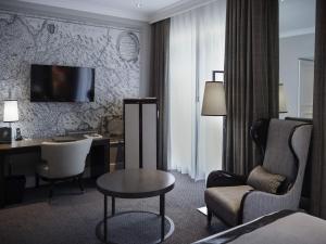 a hotel room with a desk and a chair at Park Hotel Grenoble - Handwritten Collection in Grenoble