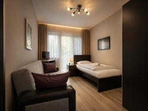 a bedroom with two beds and a couch and a window at Hotel - Pension Vesta in Bad Elster