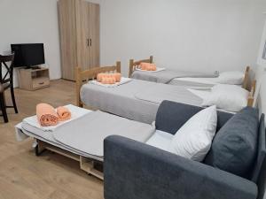 a living room with four beds and a couch at Muso Apartments in Gevgelija