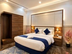 a bedroom with a large bed with a large headboard at توارن للشقق المخدومة - الاقتصادية in Riyadh +32 photos