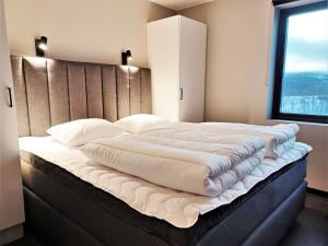 a large white bed in a room with a window at View Apartments in Åre